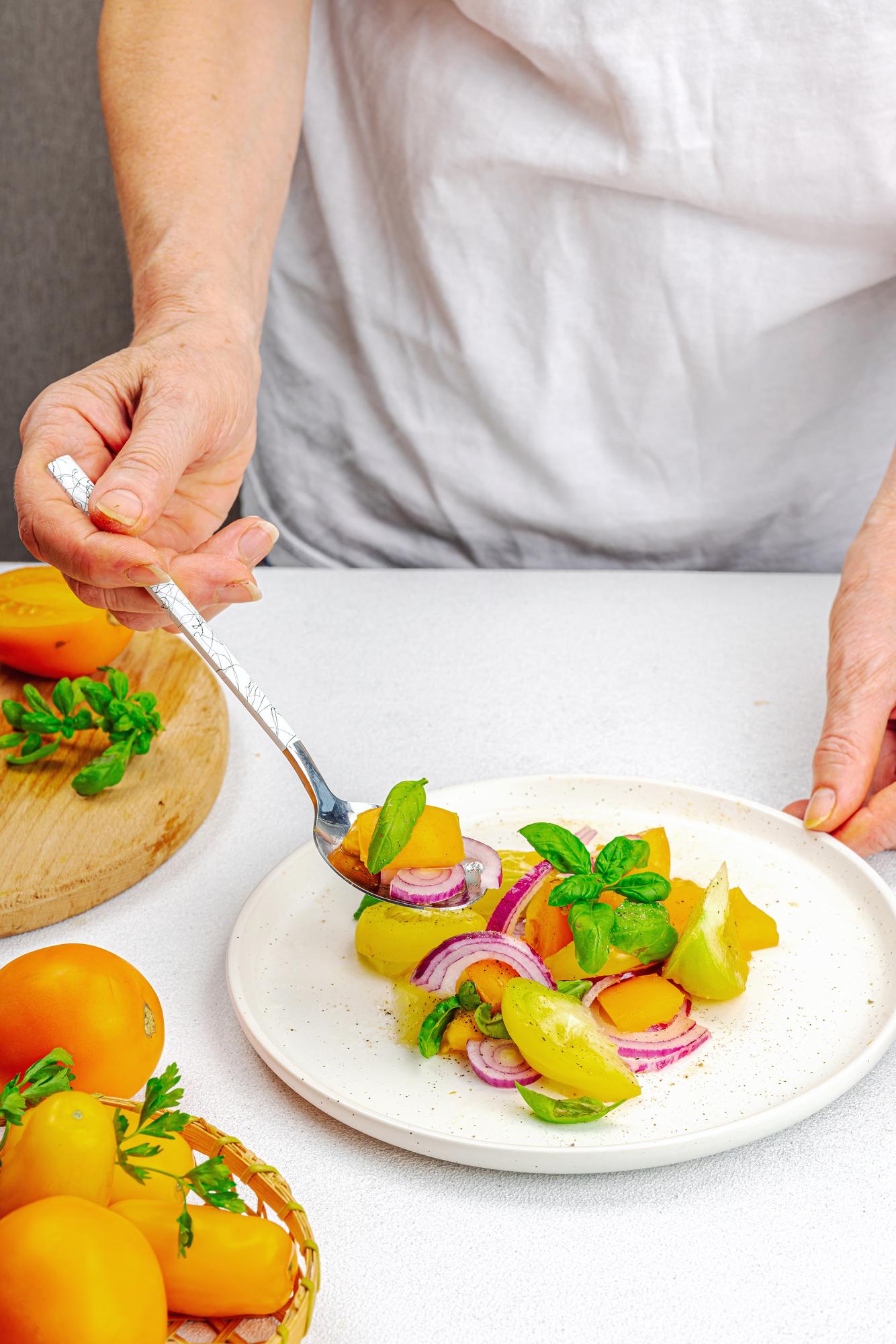 Chef plating a colorful modern dish on a wooden table
